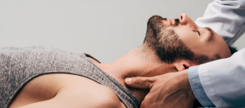 man laying down with the hands of a doctor giving him a neck and shoulder massage